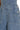 Close-up of blue denim overalls with buttons and stitching details.