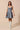 Model wearing denim flare dress styled for casual daytime outfit