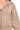 Close-up view of cocoa fleece fabric showing zip detail, ribbed trim, and pocket stitching.
