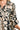 Close-up of a dress with black and beige floral pattern on a white background