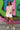 Standing in floral puff sleeve blouse with white shorts and sneakers, urban graffiti wall, midday light