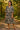 Walking in floral tiered midi dress with brown sandals, forest path in morning light