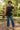 Woman posing in black flowy round hem rayon t-shirt with jeans and wedges, park fountain daylight.
