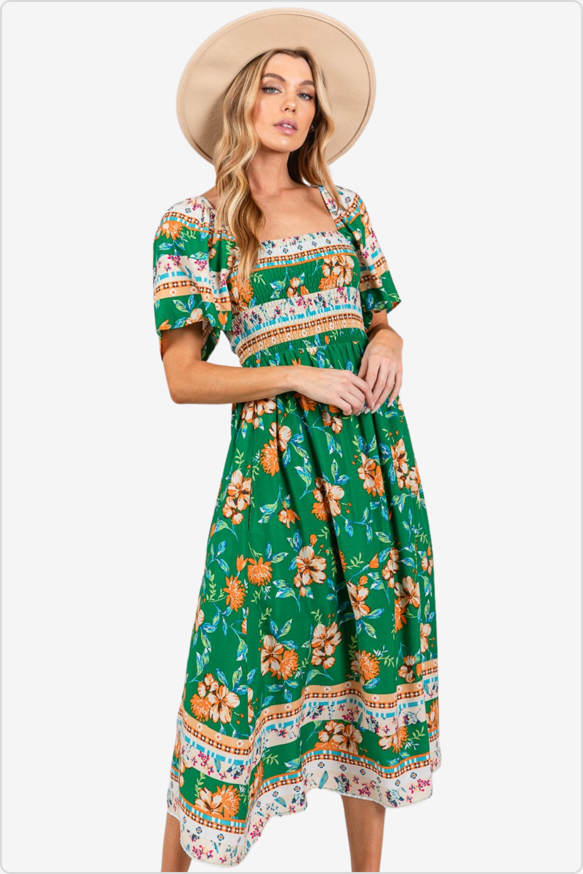 Stylish woman in a green floral print maxi dress with puff sleeves and a beige sun hat, ideal for a summer day or tropical getaway.