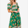 Stylish woman in a green floral print maxi dress with puff sleeves and a beige sun hat, ideal for a summer day or tropical getaway.