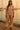 Woman in jacquard floral knit hoodie with puff sleeves, satin joggers, and sandals at marina sunset