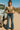 Woman standing in Ribbed Knit Top with flare jeans and boots, by vintage truck, desert daylight