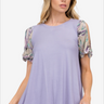 Woman sporting a soft lavender blouse with floral sleeve accents, perfect for a light summer vibe.