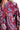 Close-up view of wine mix fabric with paisley print and high-low hem detail.