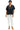 Model wearing bow print blouse with white trousers for a clean look.