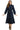 Woman wearing a navy blue dress with long sleeves on a white background