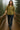 Woman in olive green shirt with jacquard hearts, jeans and boots, on a foggy forest bridge