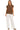 Woman wearing a brown top and white pants on a white background
