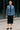 Woman in paisley shirt with black skirt and tie outside office building