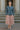 Woman in paisley denim shirt and blush tulle skirt standing on classic stone stairs