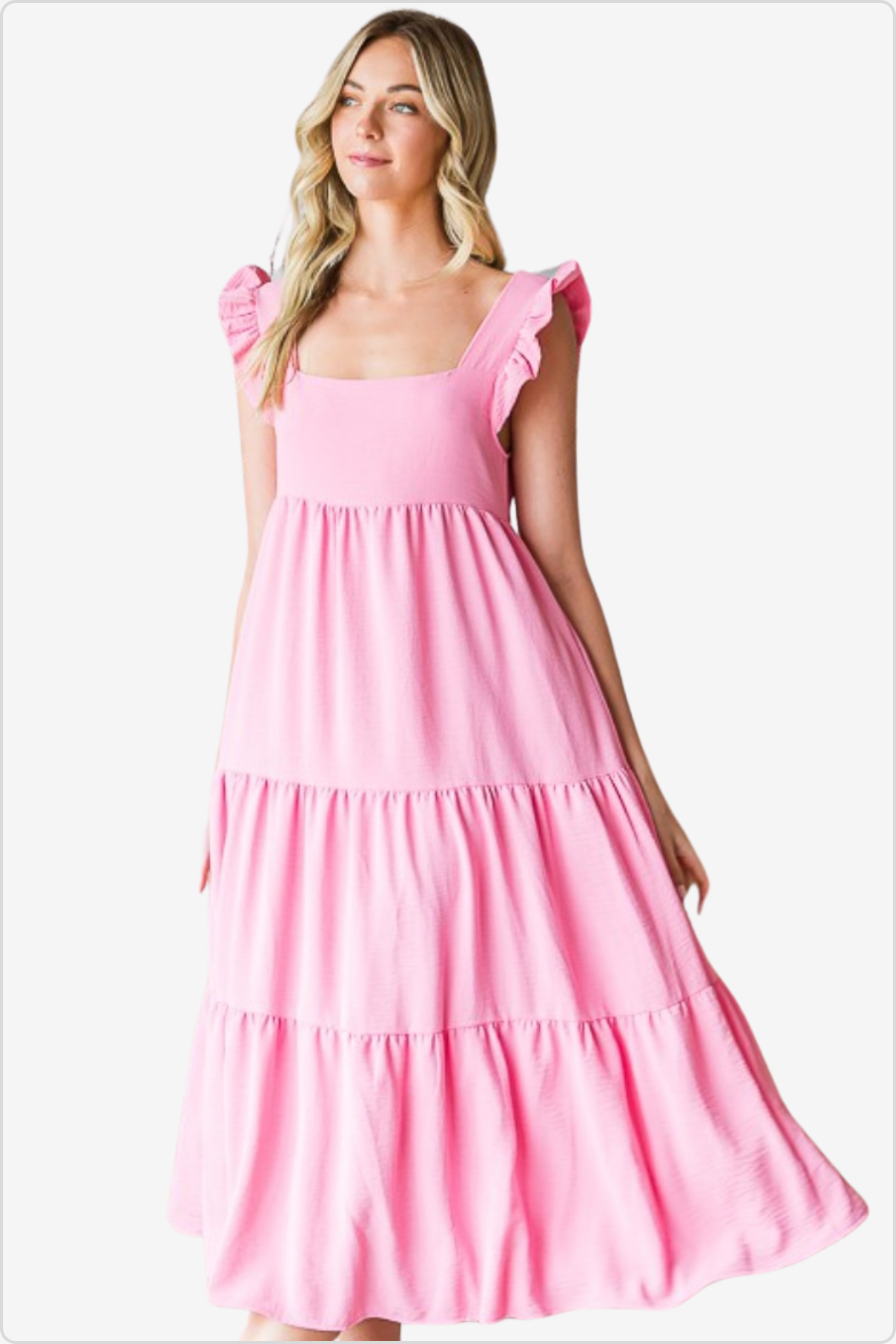 Light pink summer dress with ruffle sleeves and tiered skirt, styled with simple white sandals, perfect for a sunny day out.