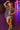 Woman posing in a plaid shirt and silver skirt with neon lights in the background