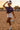 Woman in cowboy hat and boots posing in a dirt field with sunset