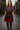 Woman in traditional Scottish attire standing on a cobblestone street.