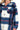 Close-up view of navy plaid fleece fabric with button detail and chest pocket flap