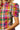 Multicolored plaid shirt worn by a person on a white background