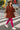 Model walking across Shibuya crosswalk in red-brown corduroy mini dress with pink tights and sneakers, city afternoon