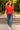 Walking in red polo sweatshirt with jeans, white sneakers and gold jewelry, park steps, midday sun