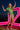 Dancing on rooftop in retro floral blouse with silver shorts and heels, neon light at night