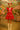 White model in red ruffled dress with umbrella, white socks, and Mary Janes at colorful fair scene