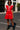 African American model in red ruffled mini dress with fishnet tights and combat boots on city street