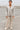 Woman in satin shirt and beige cargo pants with sneakers standing on rooftop parking