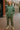 Standing in oversized scuba hoodie with camo cargo pants and combat boots, city street, overcast daylight