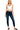 Woman wearing a white tank top and dark blue jeans on a white background
