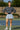 Woman in a striped sweater and pleated skirt standing on a tennis court