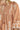 Brown dress with white floral patterns and tassels on a close-up view