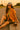 Sitting on curb in textured cotton-blend shirt with biker shorts and scarf, roadside, sunset