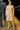 Latina model in beige turtleneck sweater dress with yellow tights and metallic flats in NYC subway