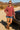 Woman leaning on jeep in dark red turtleneck sweater, with lace-up boots, desert sun