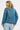 Person wearing a blue denim jacket on a white background