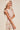 Model side view showing flowing silhouette and tied straps