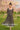 Woman in checker mesh dress holding tulips in blooming spring garden