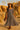 Woman in checker mesh dress with fringe bag and hat in desert setting