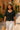 Black crochet short sleeve top styled with straw hat and cream trousers for summer elegance