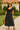 Latin Women's black midi dress with white polka dots, puff sleeves, and tie front styled for a retro-inspired look.