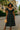 Women's black midi dress with white polka dots, puff sleeves, and tie front styled for a retro-inspired look.