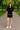 Casual women's black shirt and shorts set with sneakers, perfect for sunny park stroll.