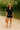 Women's black woven set with contrast trim, styled with straw hat and summer heels by the river.