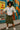 Woman in cactus print blouse and cargo skirt posing confidently in front of urban mural.