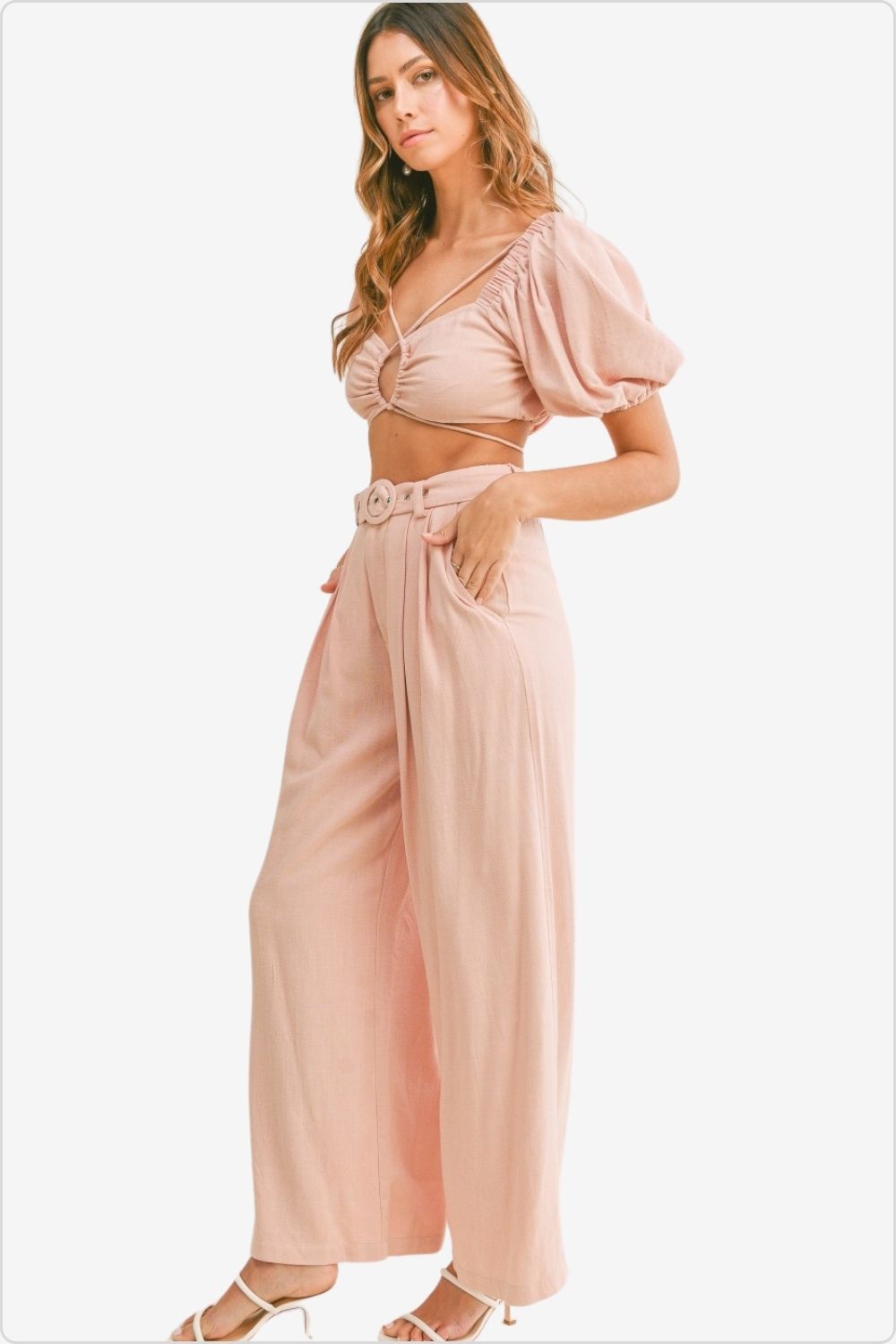 Fashion-forward woman in a cut out drawstring crop top and belted pants set, showcasing modern style, Color Dusty Pink