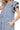 Close-up of ruffle sleeve and pocket stitching on navy dress showing textured fabric